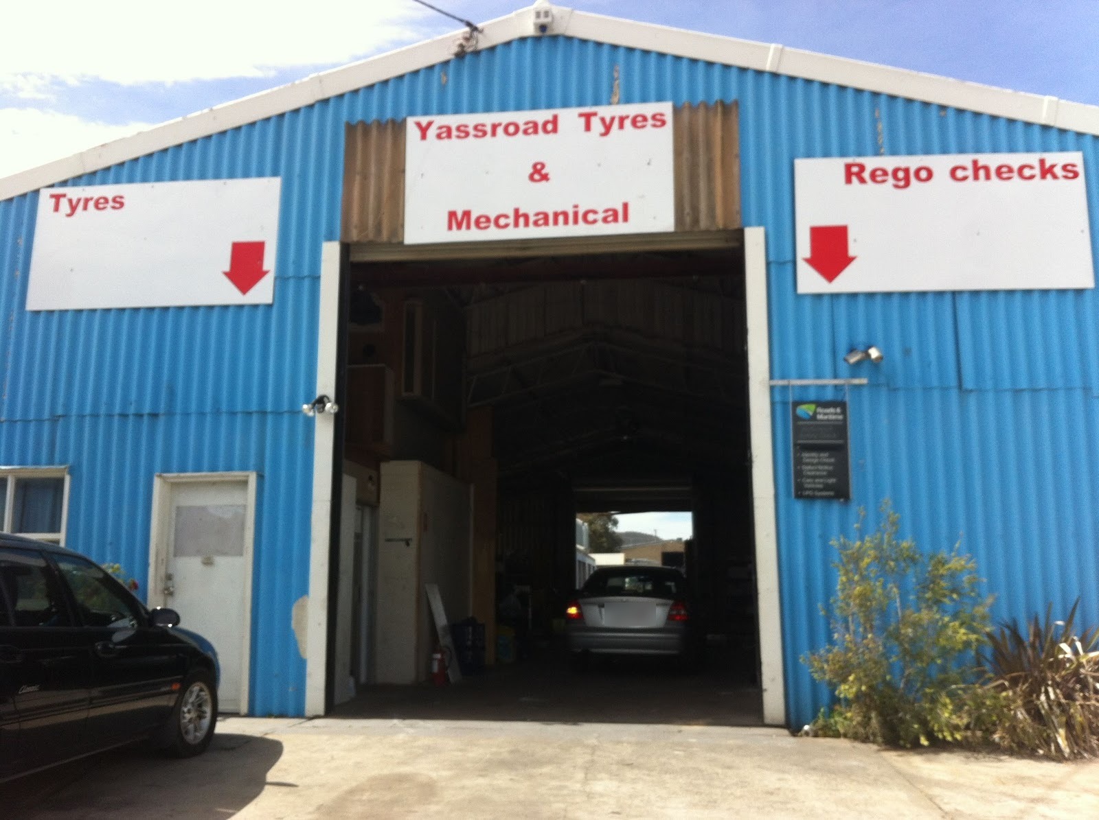 Front of the shed with the roller door open and a car in the bay