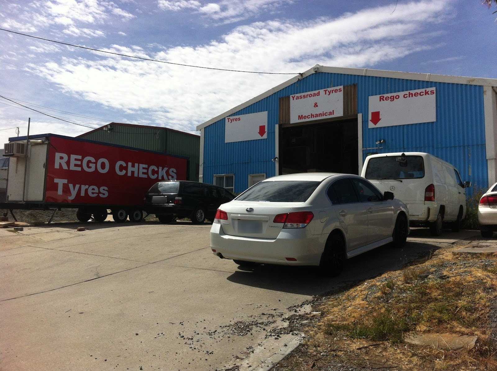 The driveway at 4 Bayldon Rd with the red Rego Checks trailer and the blue shed